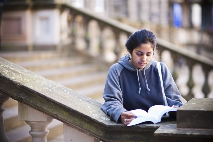 Student reading alone outside