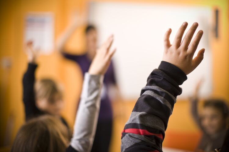 Classroom with students with their hands up