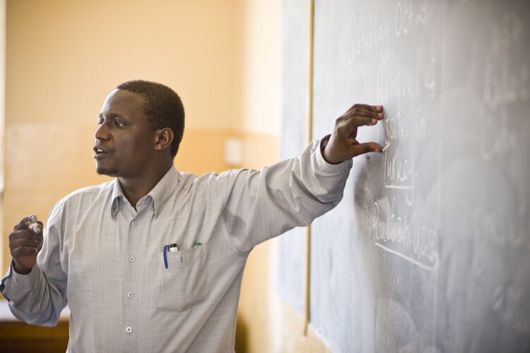 Teacher standing in front of board in classroom