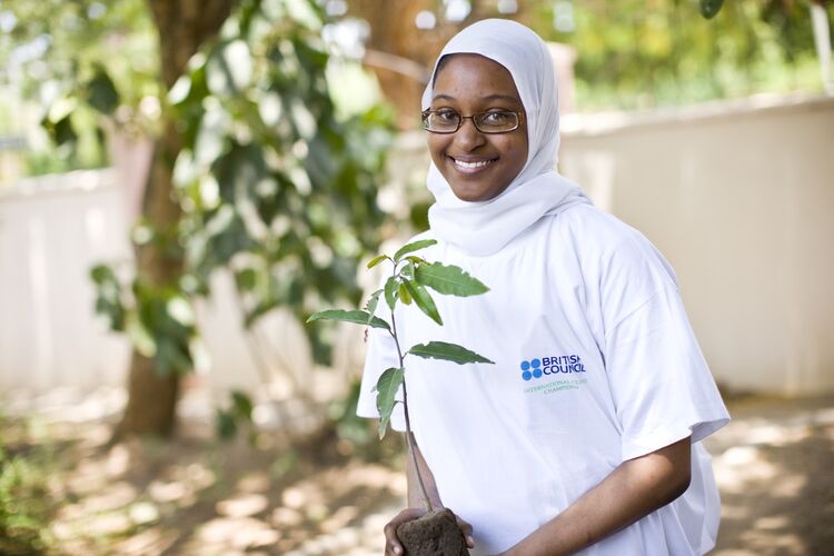 Female student in Kenya planting tree