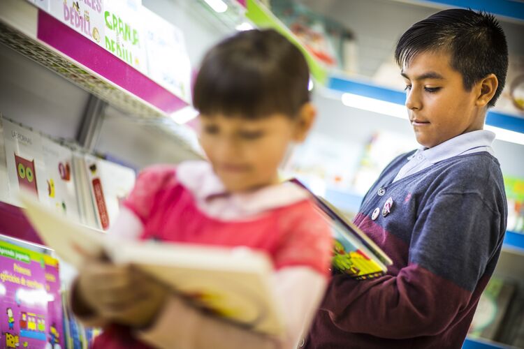 Two young learners reading in the library