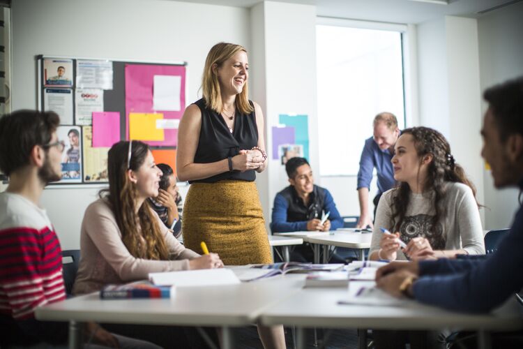 Teacher walking between students in a classroom