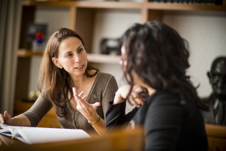 Two women talking in a library