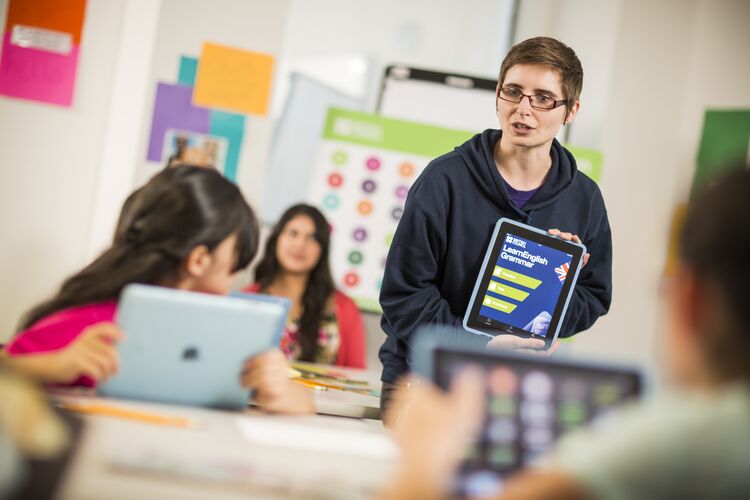 A teacher showing students a tablet