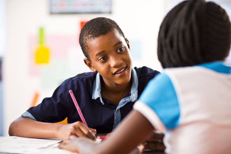 two students talking together in classroom