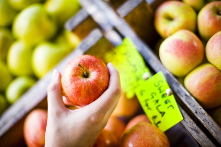 A close up of someone buying apples