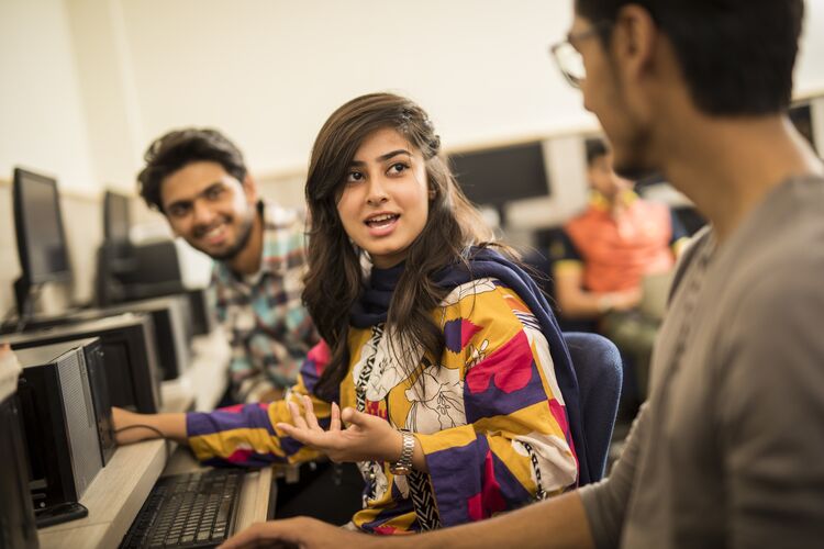 Students sitting by a computer 