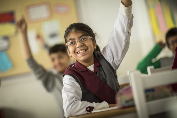 Young learner with hand up asking a question