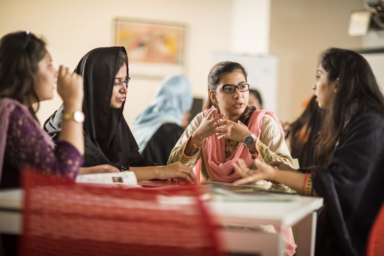 Pakistani students discussing something together in class