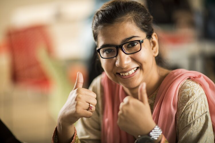 Young female teacher giving thumbs up, ok gesture