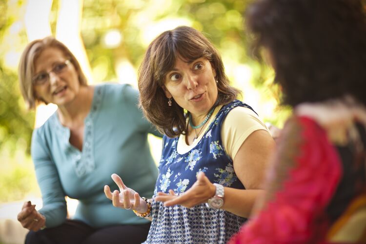 three women in conversation outdoors