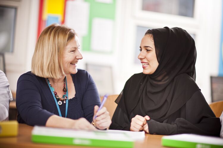 A teacher in Qatar talking with a student individually