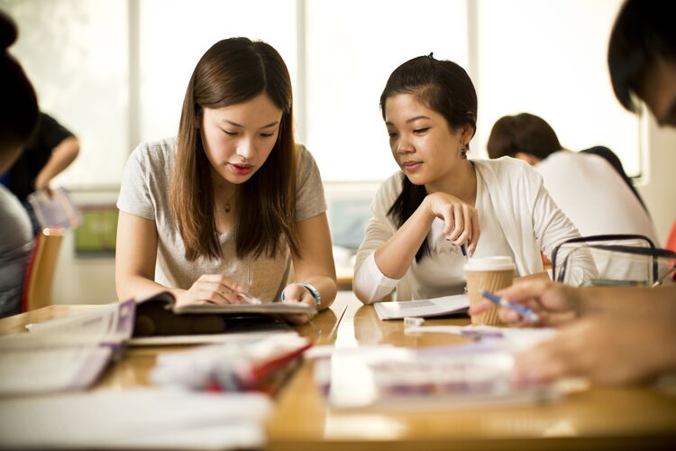 Two students in Singapore comparing notes