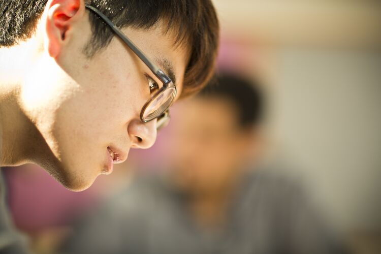 A student in Singapore looking at his work