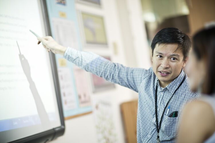 Teacher pointing at a whiteboard