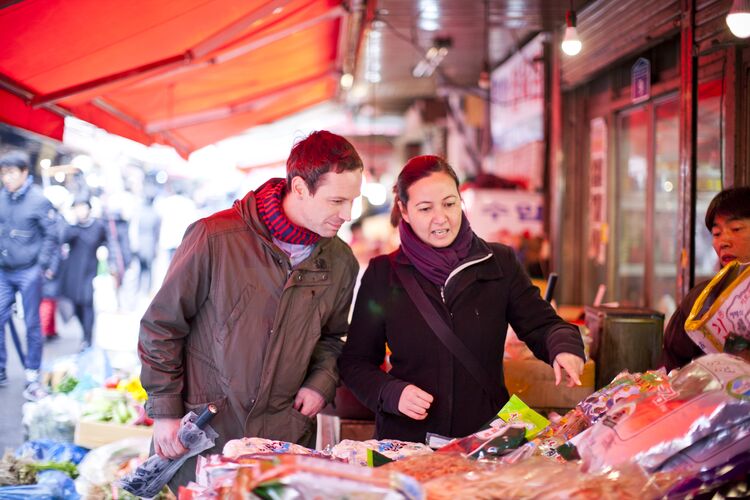 Two people looking at items in a market in South Korea