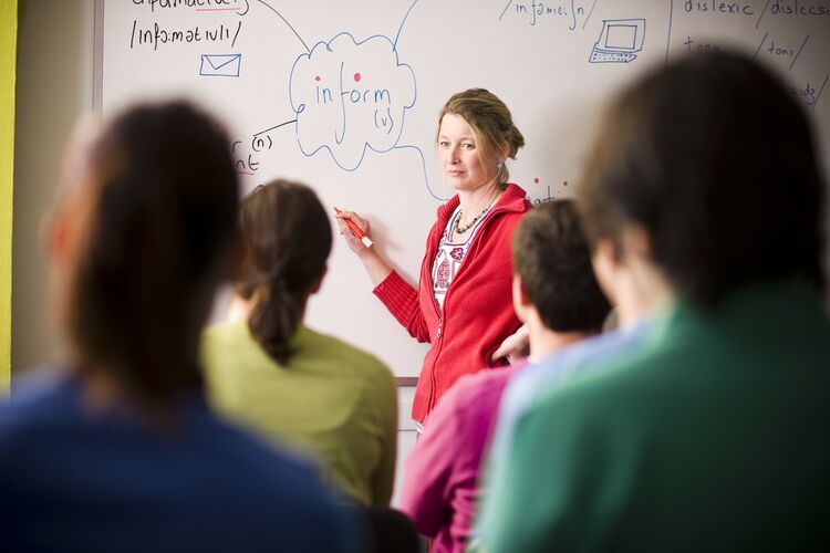 Teacher in Spain in front of board with phonetic script on