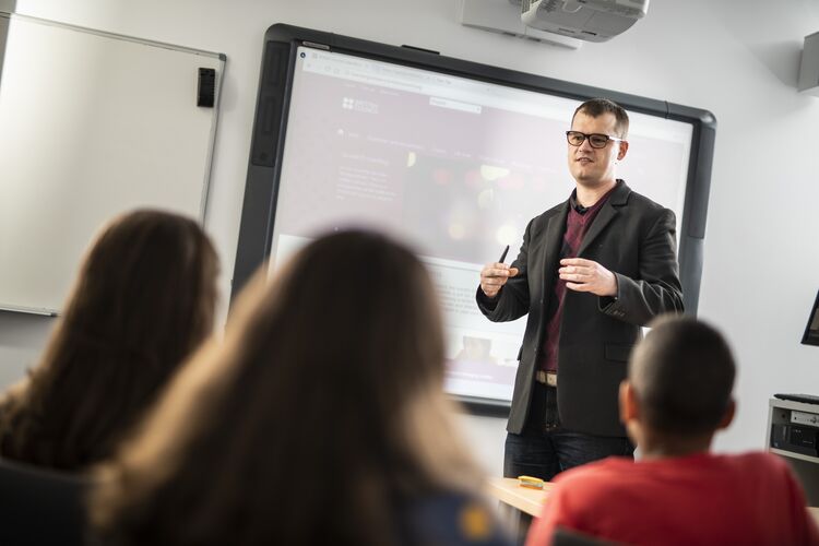 A teacher in Spain talking at the front of the class