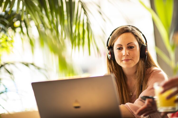 Student listening on headphones on a computer