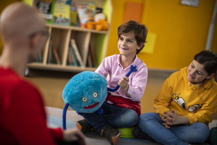 Young learner sitting with a soft toy