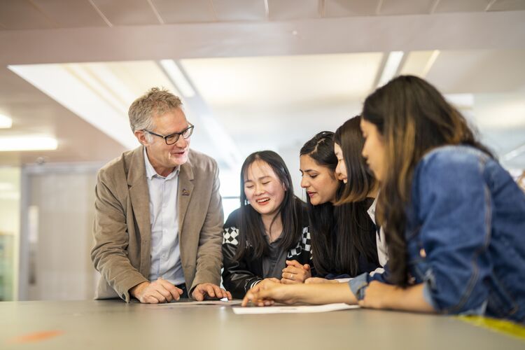 A teacher laughing with students