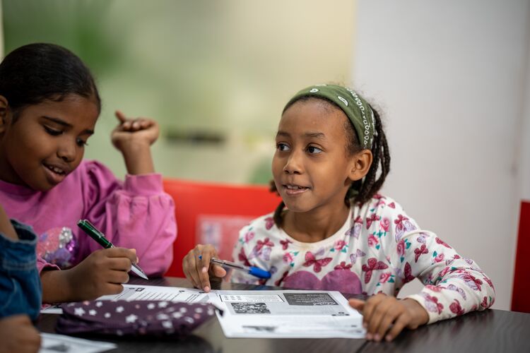 Young learner in classroom in Sudan looking at teacher