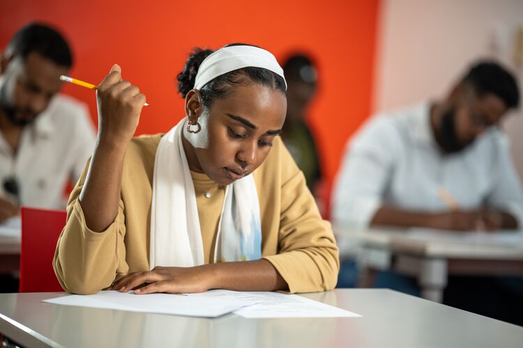 Woman sitting at desk looking at a paper