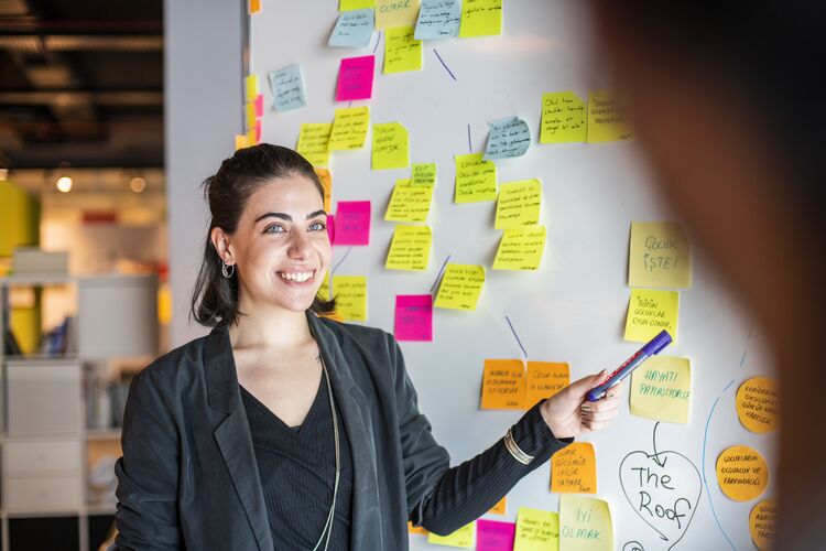 Woman standing in front of whiteboard with notes on it