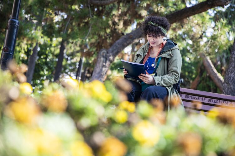 Student in Turkey reading in a park