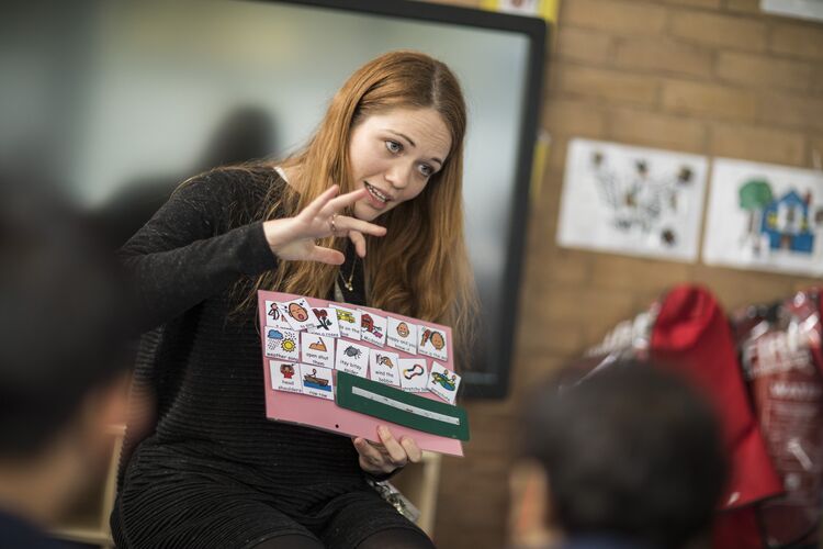 A teacher showing flashcards to their students