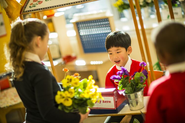 Young learners in a shopping role play in class