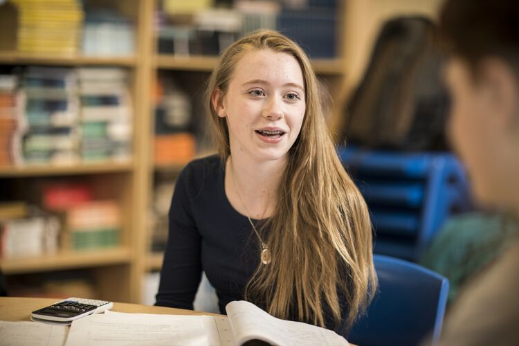 A student speaking in a library