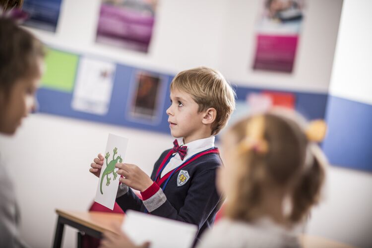 A young learner showing an image to a classmate