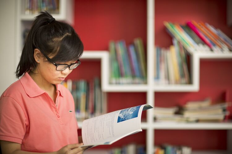 A Vietnamese student reading in a library