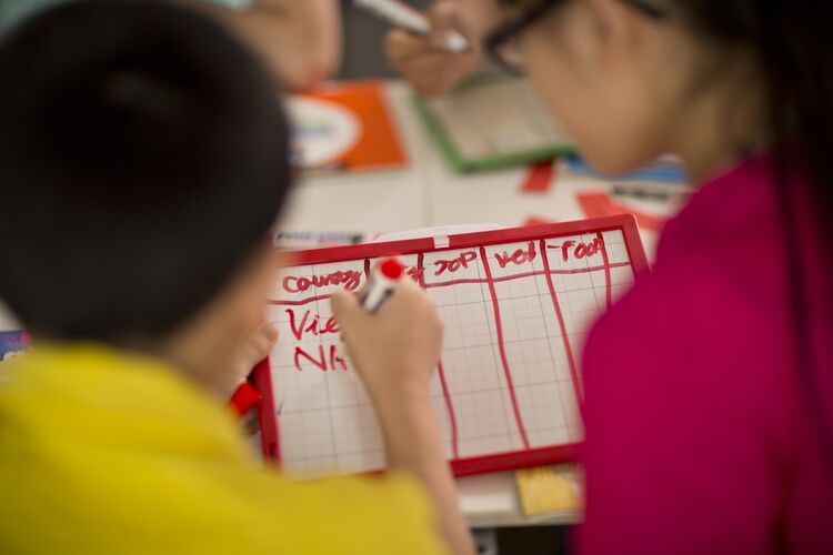 A boy writing words on a mini board