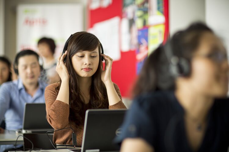 Student in Vietnam listening to headphones in class