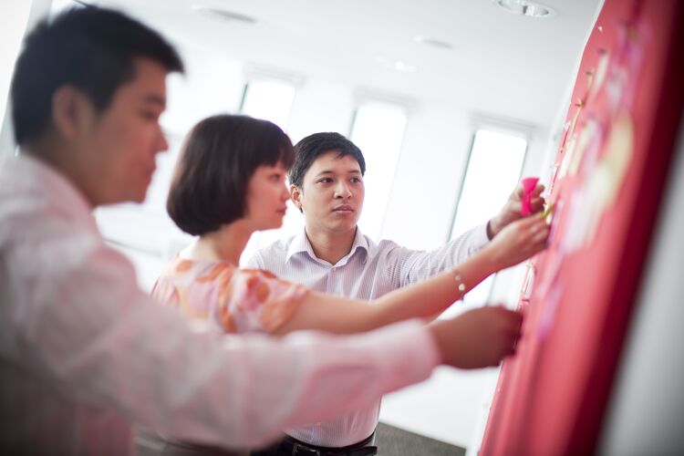 Students in Vietnam putting post-its on a board