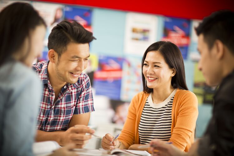 teachers meeting in a classroom and smiling