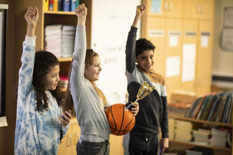 young learners with their hands up